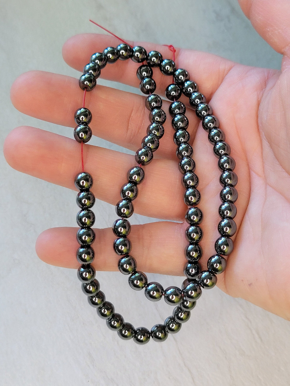 Non-magnetic synthetic hematite beads strands, aa round beads