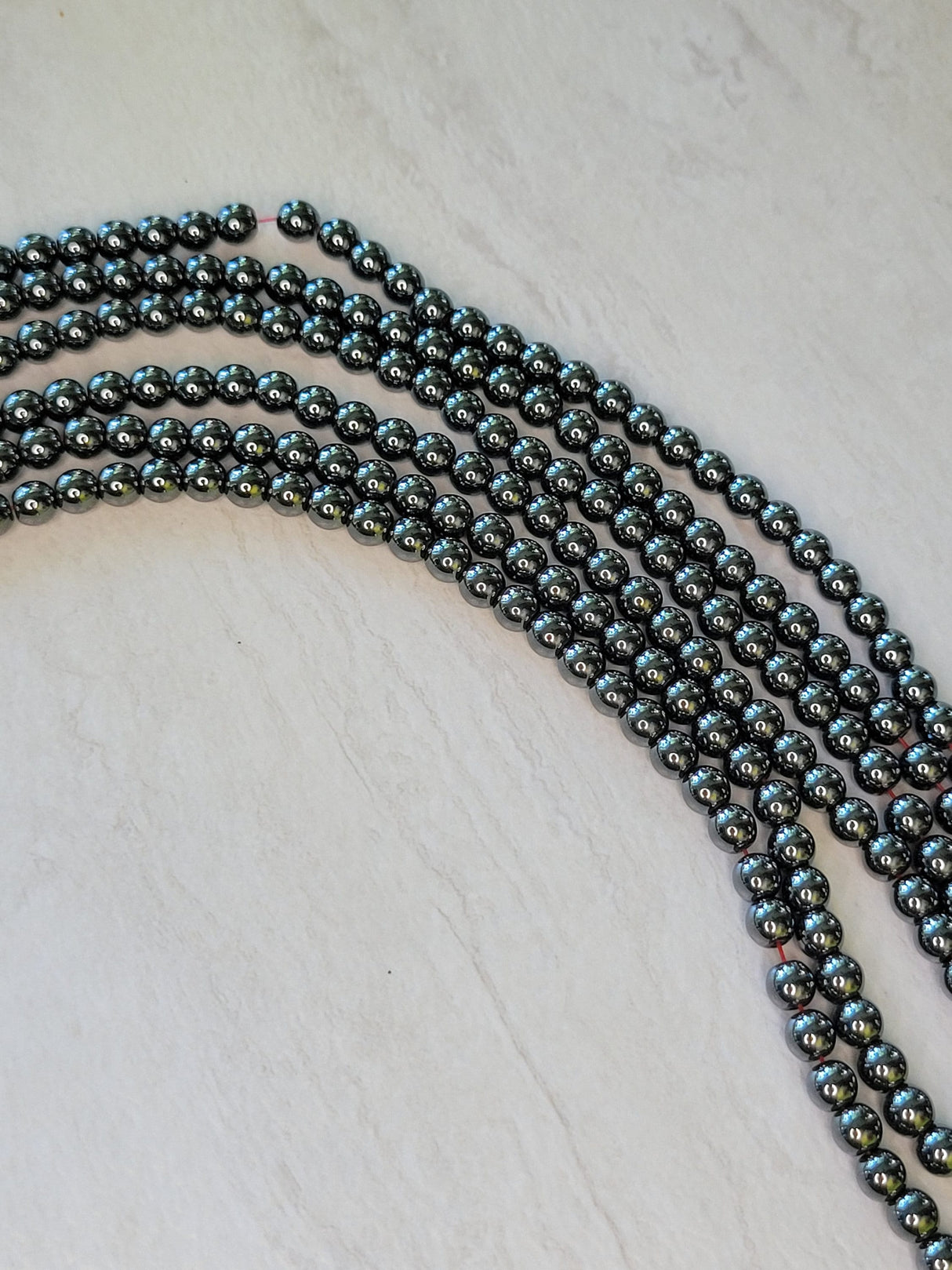Non-magnetic synthetic hematite beads strands, aa round beads
