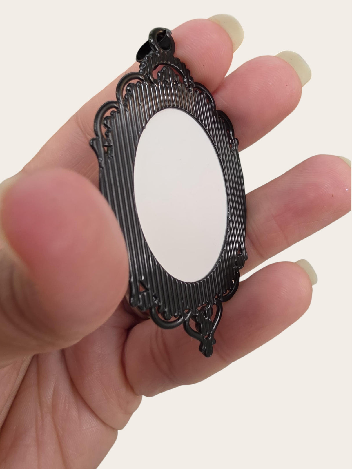 My Magic Place Shop oval black gothic pendant frame held in hand for DIY jewelry making