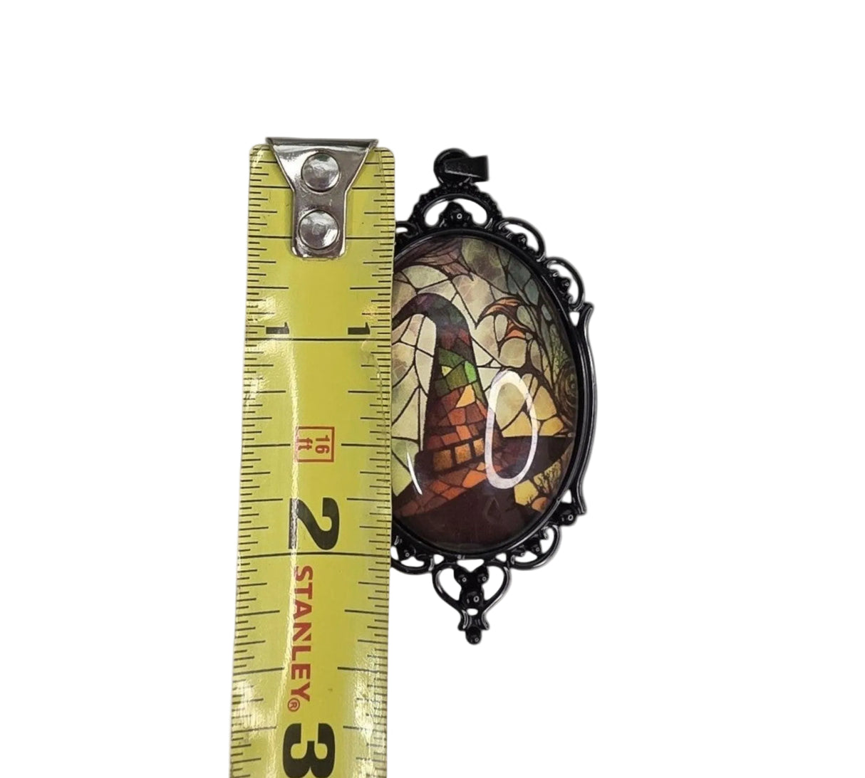 My Magic Place Shop witch hat cameo pendant with stained-glass art in an ornate black filigree frame measured by tape.
