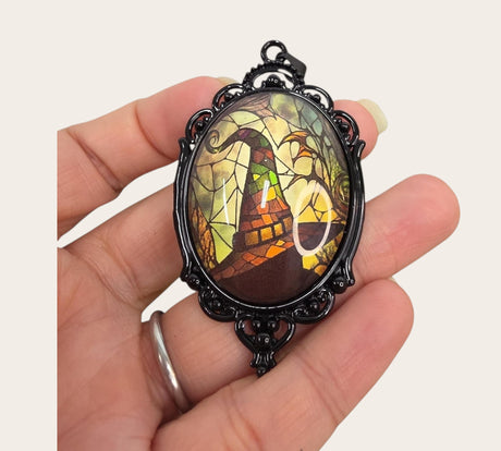 My Magic Place Shop witch hat cameo pendant with a stained-glass effect in an ornate black vintage filigree frame.